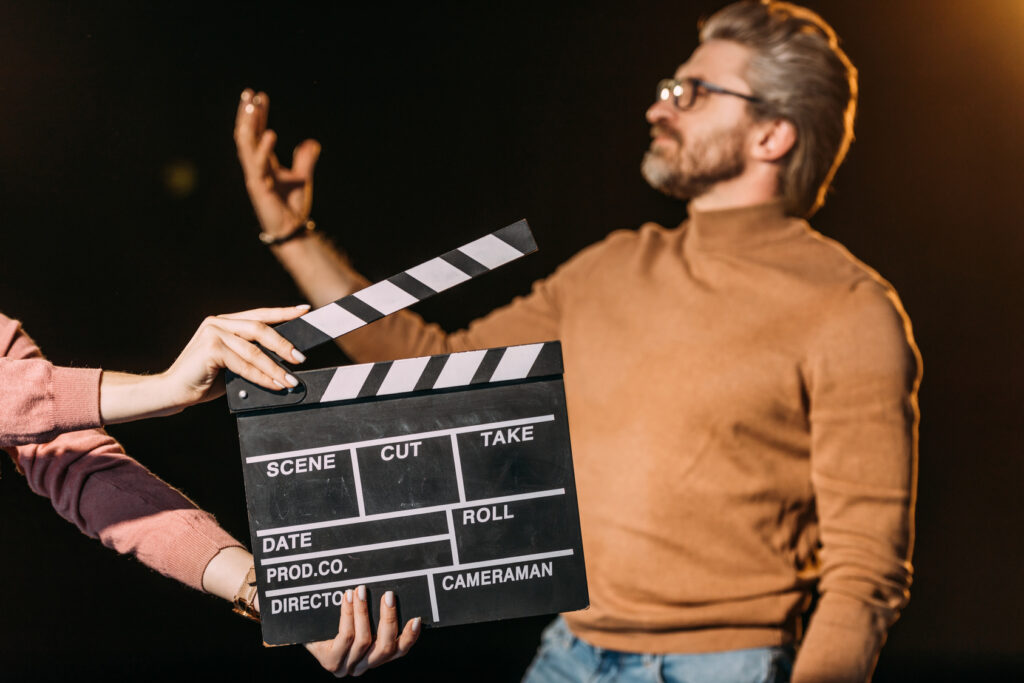 Actor holding forward a film clapperboard