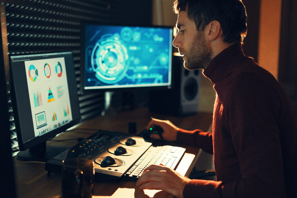 Videographer editing footage and sound at a desktop computer